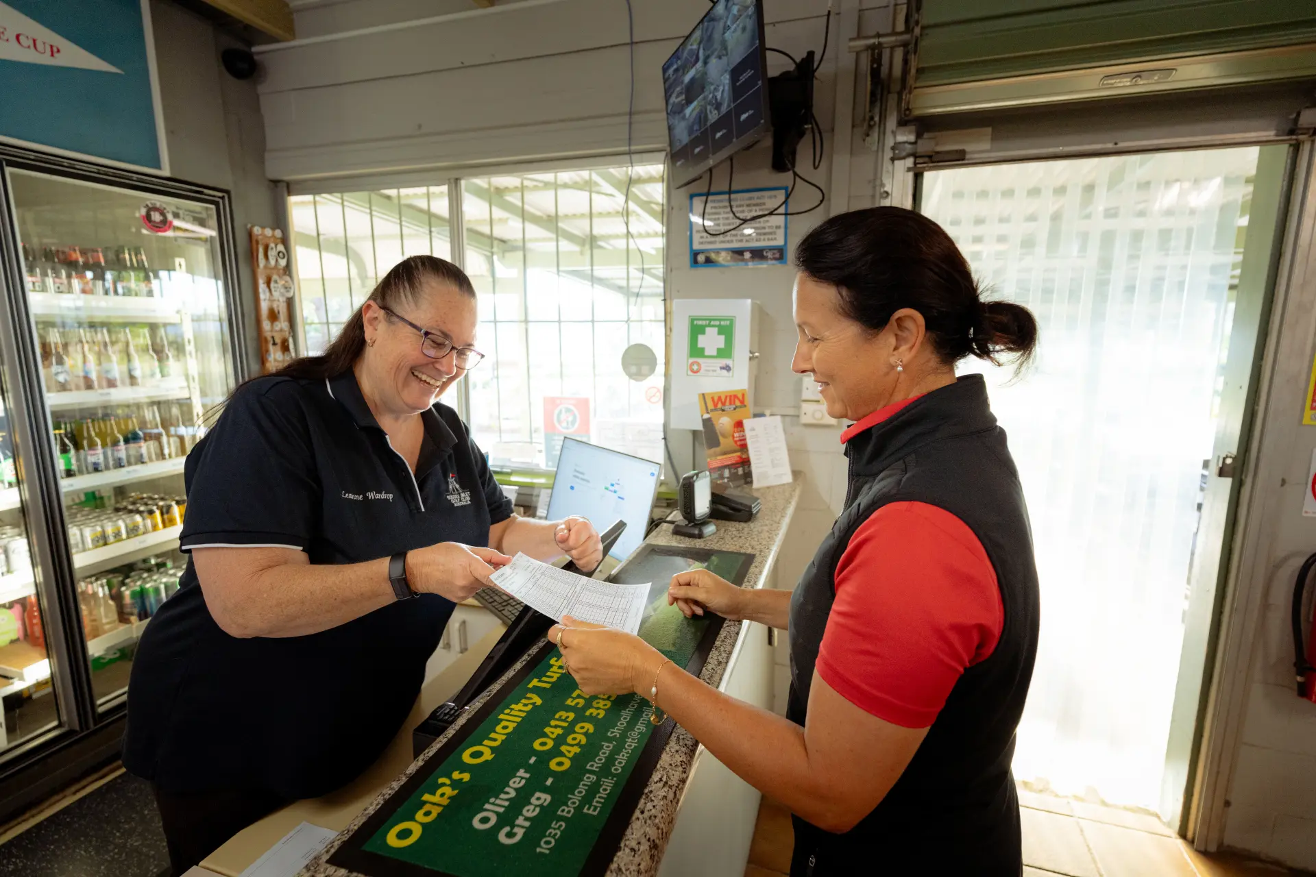 Club staff chatting with visitors across the clubhouse counter